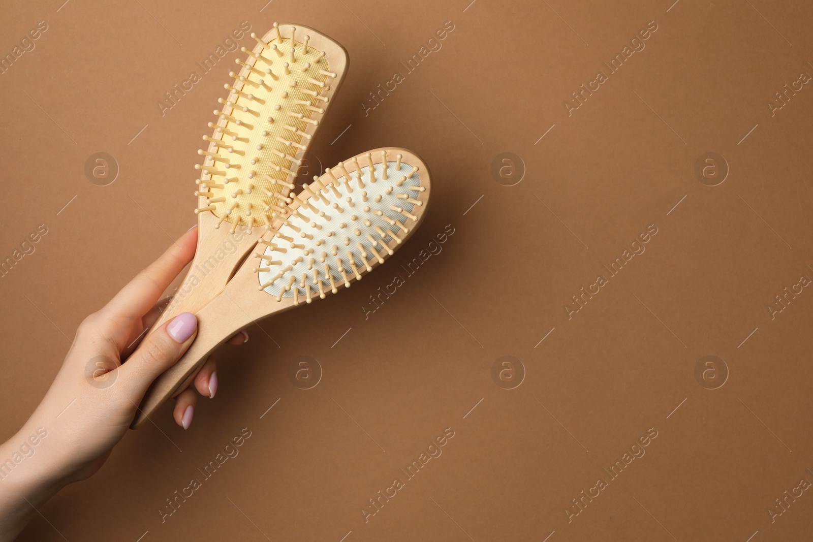 Photo of Woman with wooden brushes on beige background, closeup. Space for text