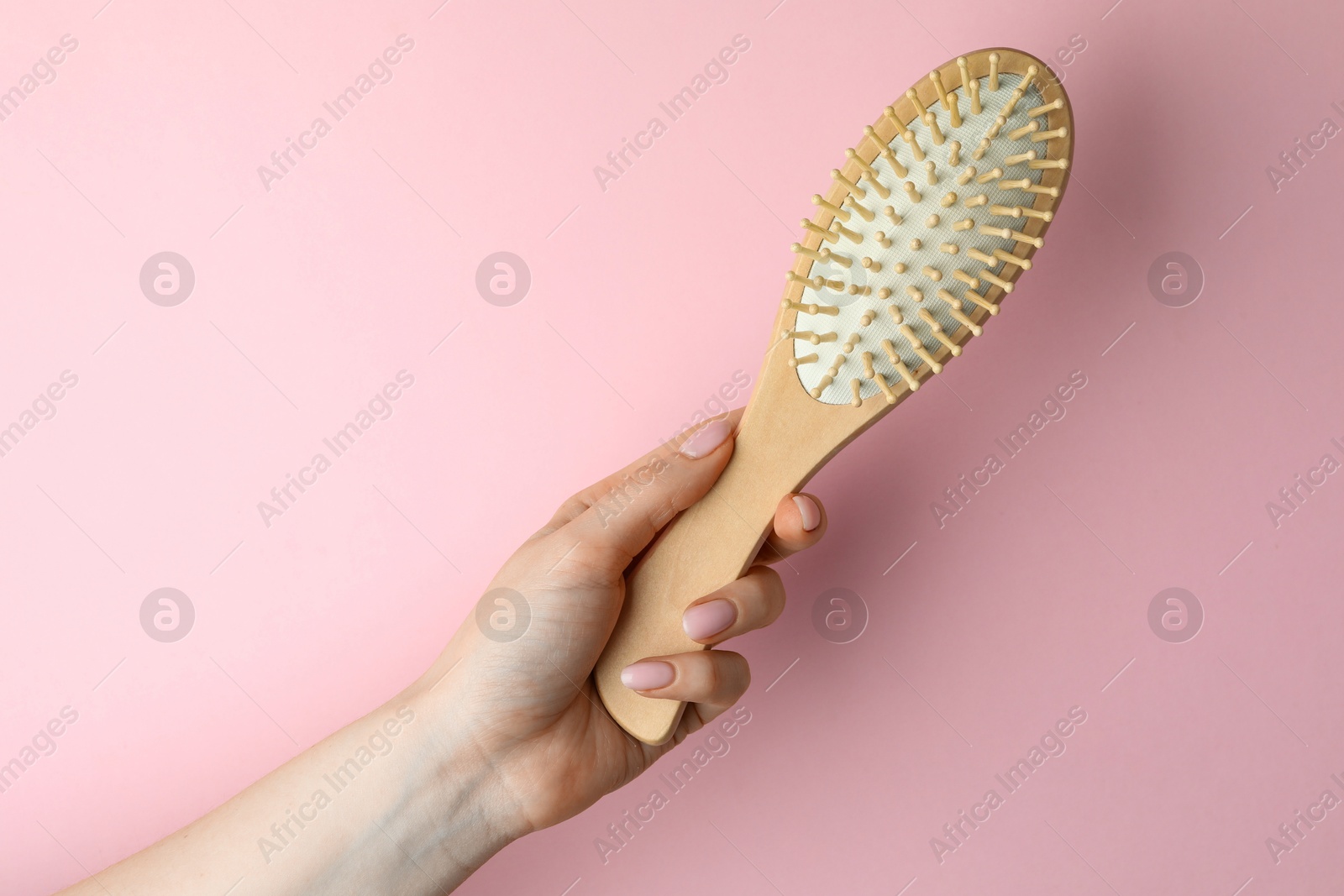 Photo of Woman with wooden brush on pink background, closeup