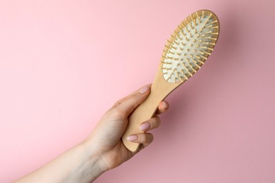 Photo of Woman with wooden brush on pink background, closeup