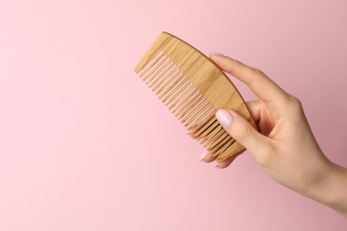 Photo of Woman with wooden comb on pink background, closeup. Space for text