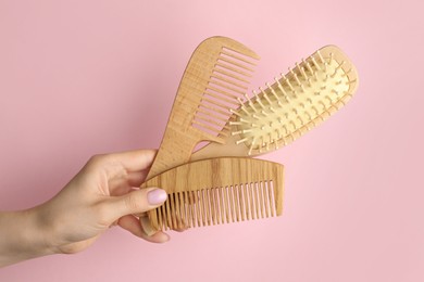 Photo of Woman with wooden brush and combs on pink background, closeup