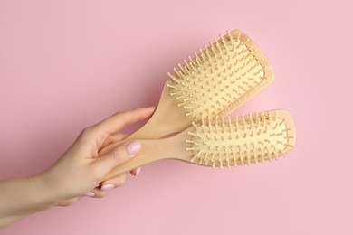 Photo of Woman with wooden brushes on pink background, closeup