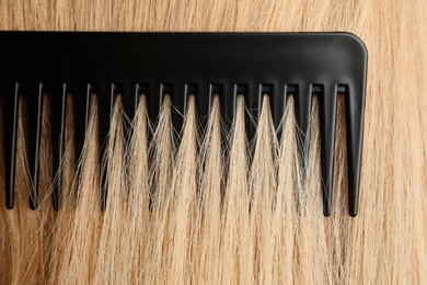 Photo of Brushing hair with plastic comb, closeup view