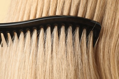 Photo of Brushing hair with plastic comb, closeup view