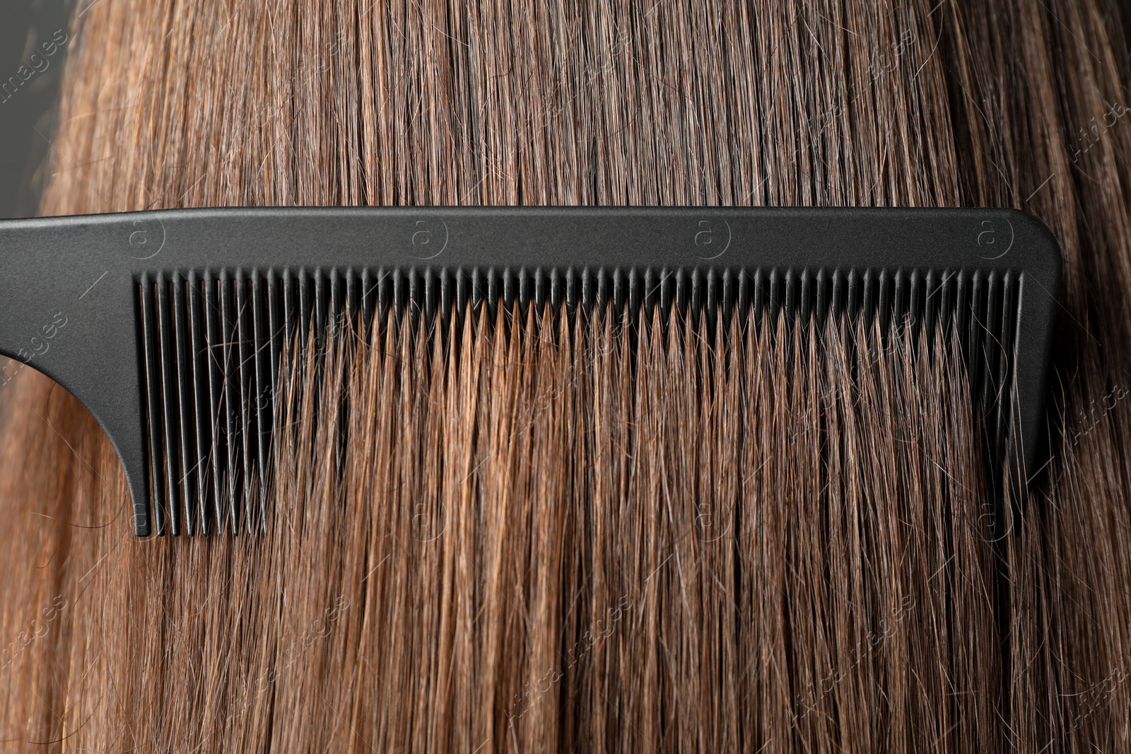 Photo of Brushing hair with plastic comb, closeup view