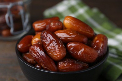 Photo of Tasty dried dates in bowl on table, closeup