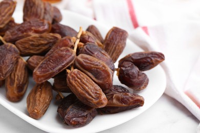 Photo of Tasty dried dates on white table, closeup