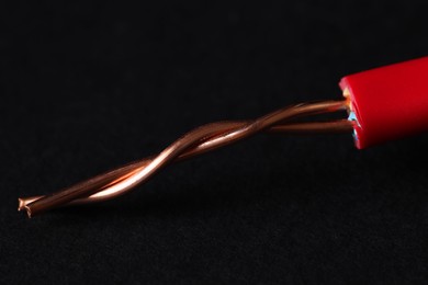 Photo of Red stripped electrical wire on black background, closeup