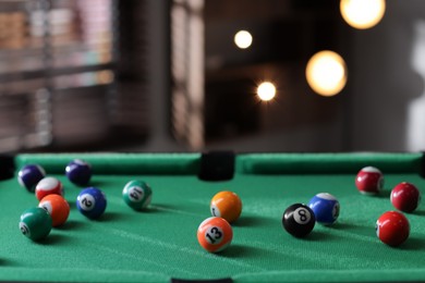 Photo of Many colorful billiard balls on green table indoors, space for text