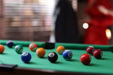 Photo of Many colorful billiard balls on green table indoors, closeup. Space for text