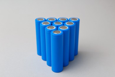 Photo of Many AA cell batteries on light grey background, closeup