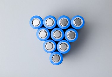 Photo of Many AA cell batteries on light grey background, top view