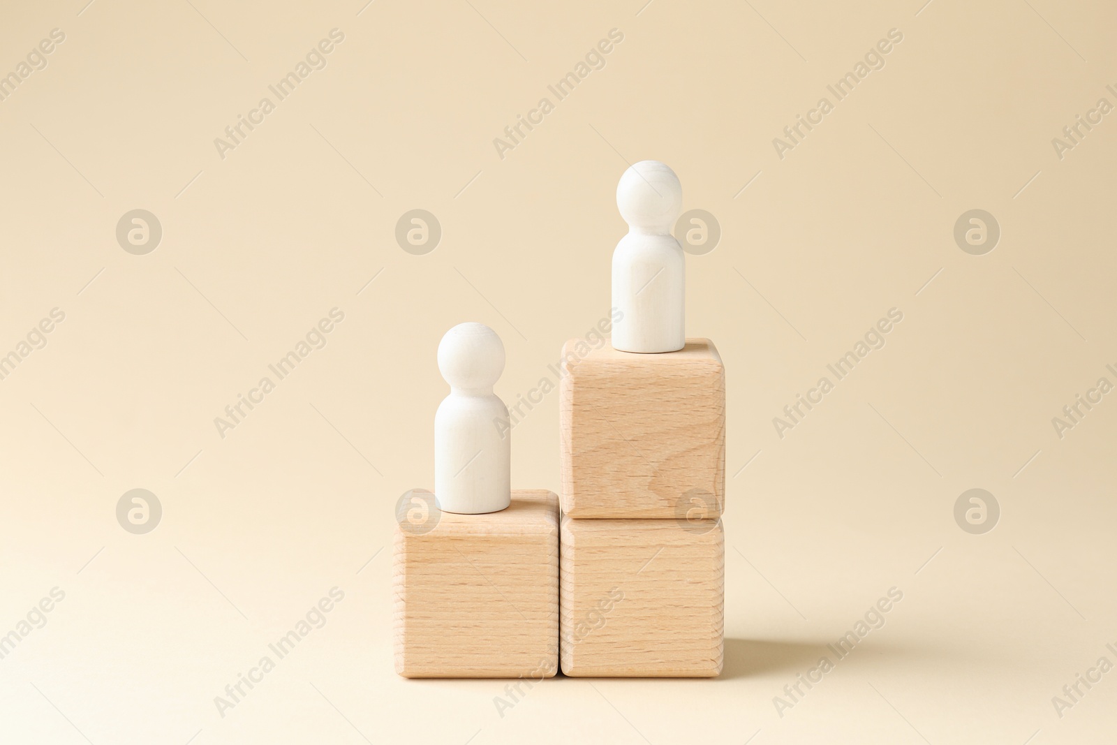 Photo of Competition concept. Human figures on wooden cubes against beige background