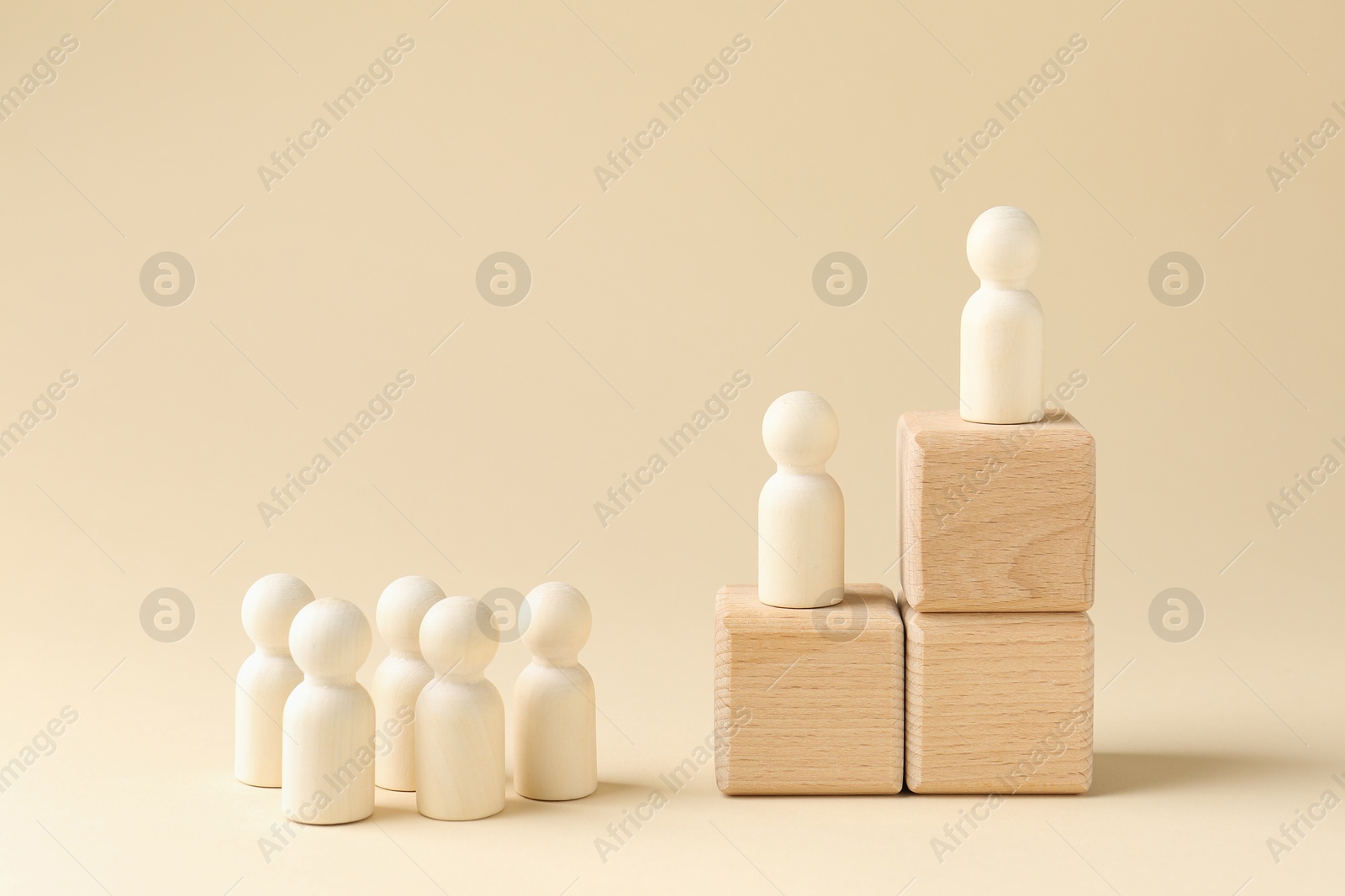 Photo of Competition concept. Human figures on wooden cubes and other ones behind against beige background, space for text