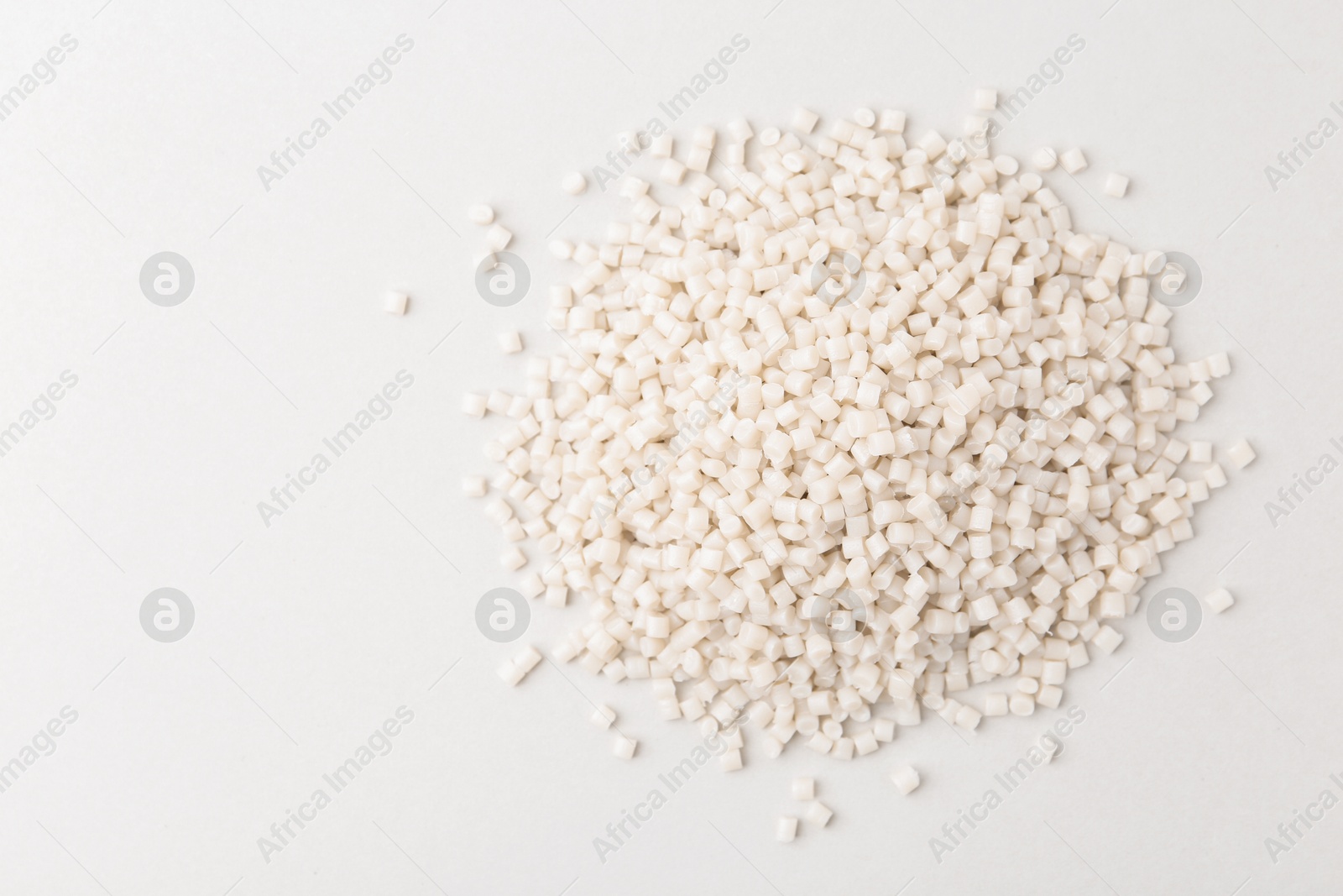 Photo of Pile of plastic granules on white background, top view. Space for text