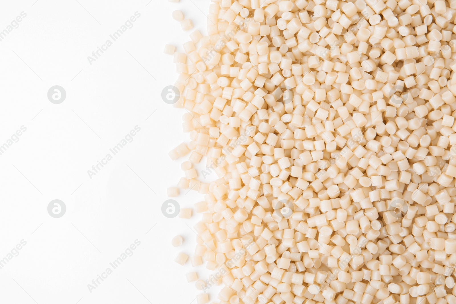 Photo of Pile of plastic granules on white background, top view. Space for text