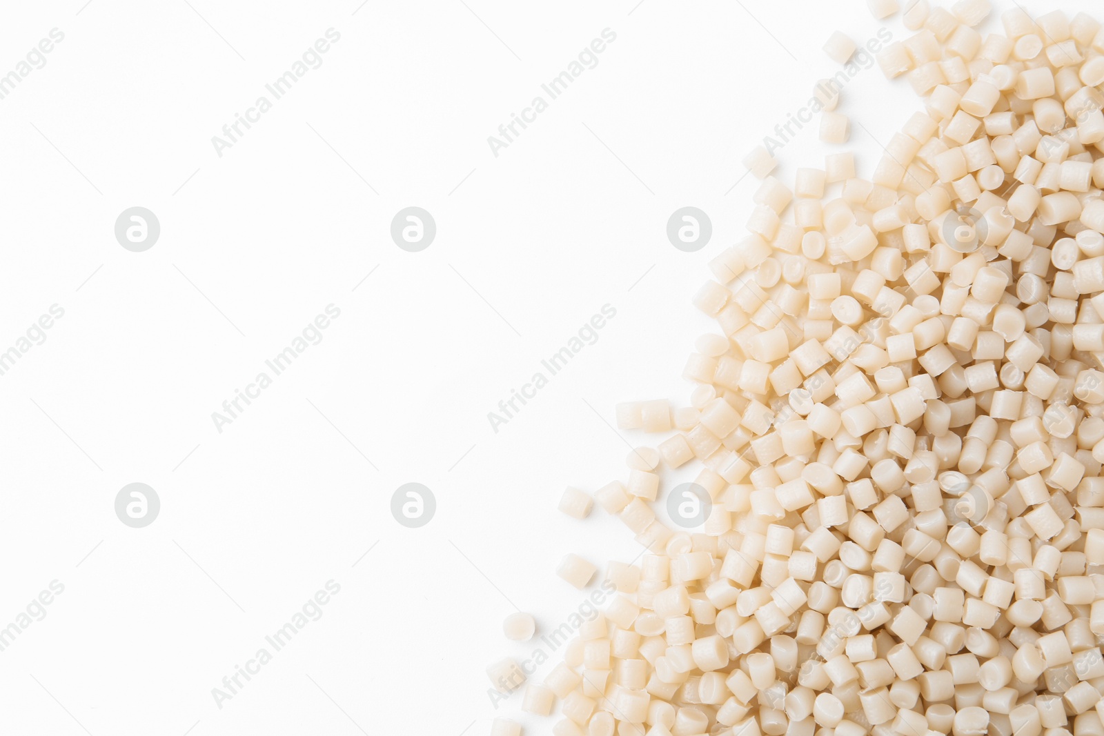 Photo of Pile of plastic granules on white background, top view. Space for text