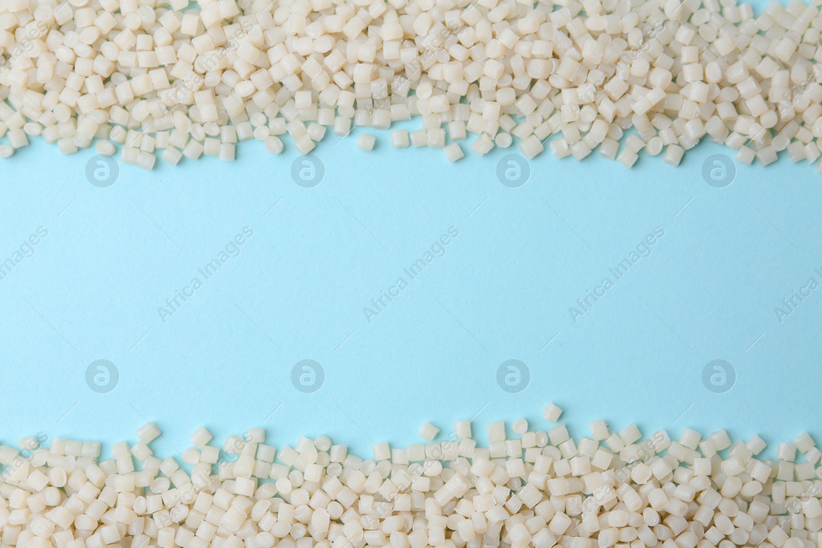 Photo of Pile of plastic granules on light blue background, top view. Space for text