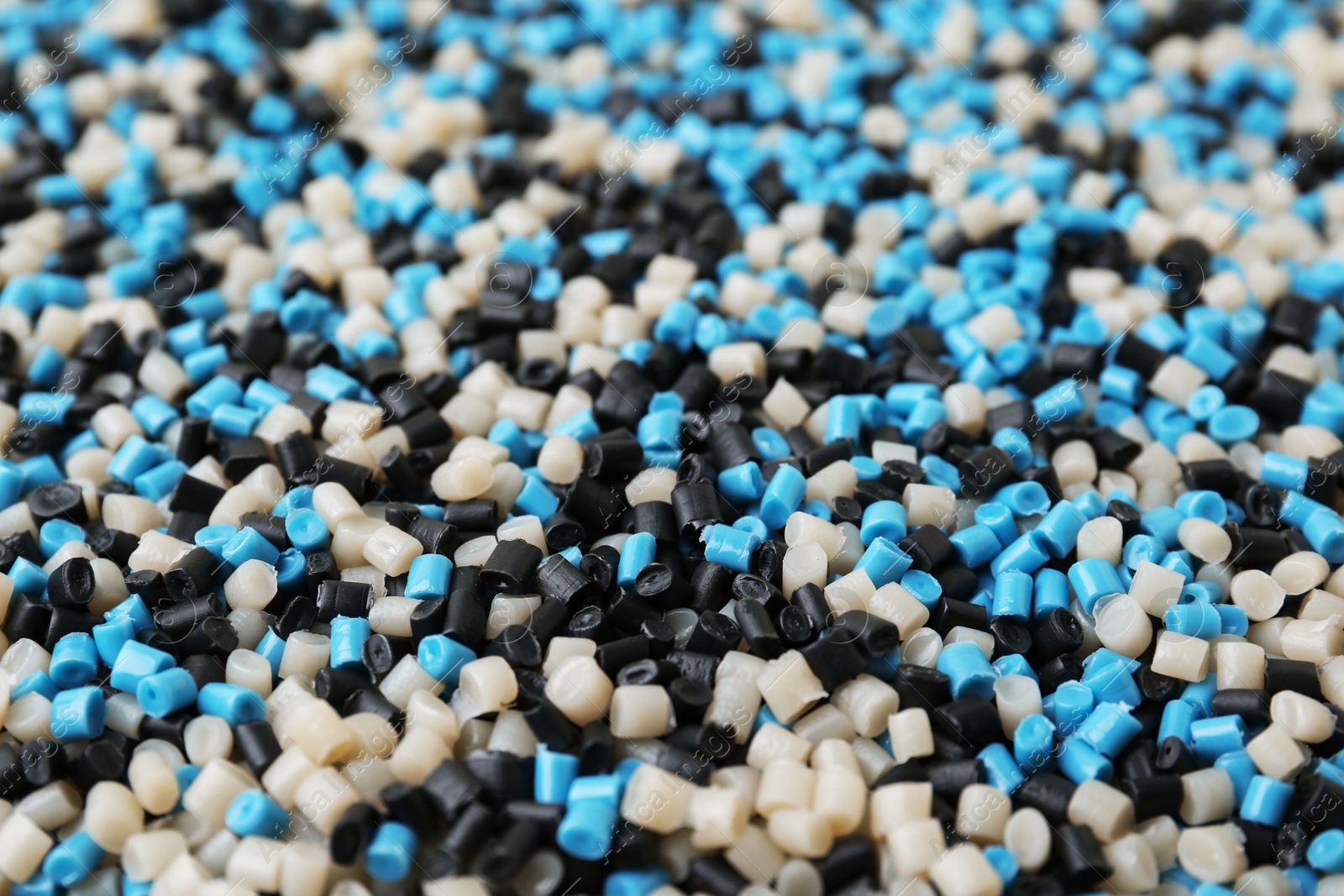 Photo of Pile of colorful plastic granules as background, closeup