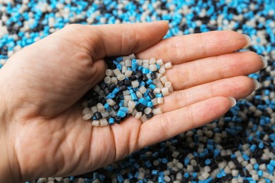 Photo of Woman with colorful plastic granules on blurred background, closeup