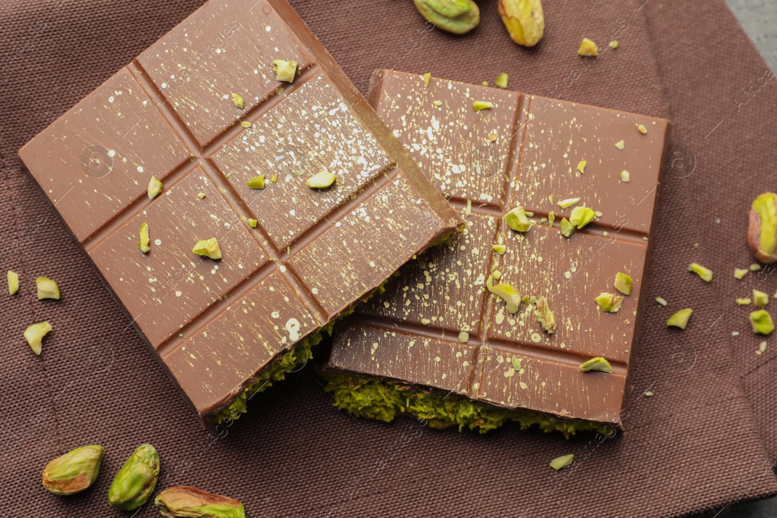 Photo of Pieces of tasty Dubai chocolate with pistachios and knafeh on table, top view