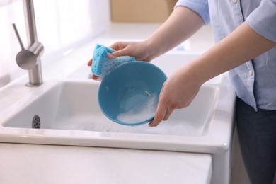 Photo of Woman washing dishes in kitchen sink, closeup