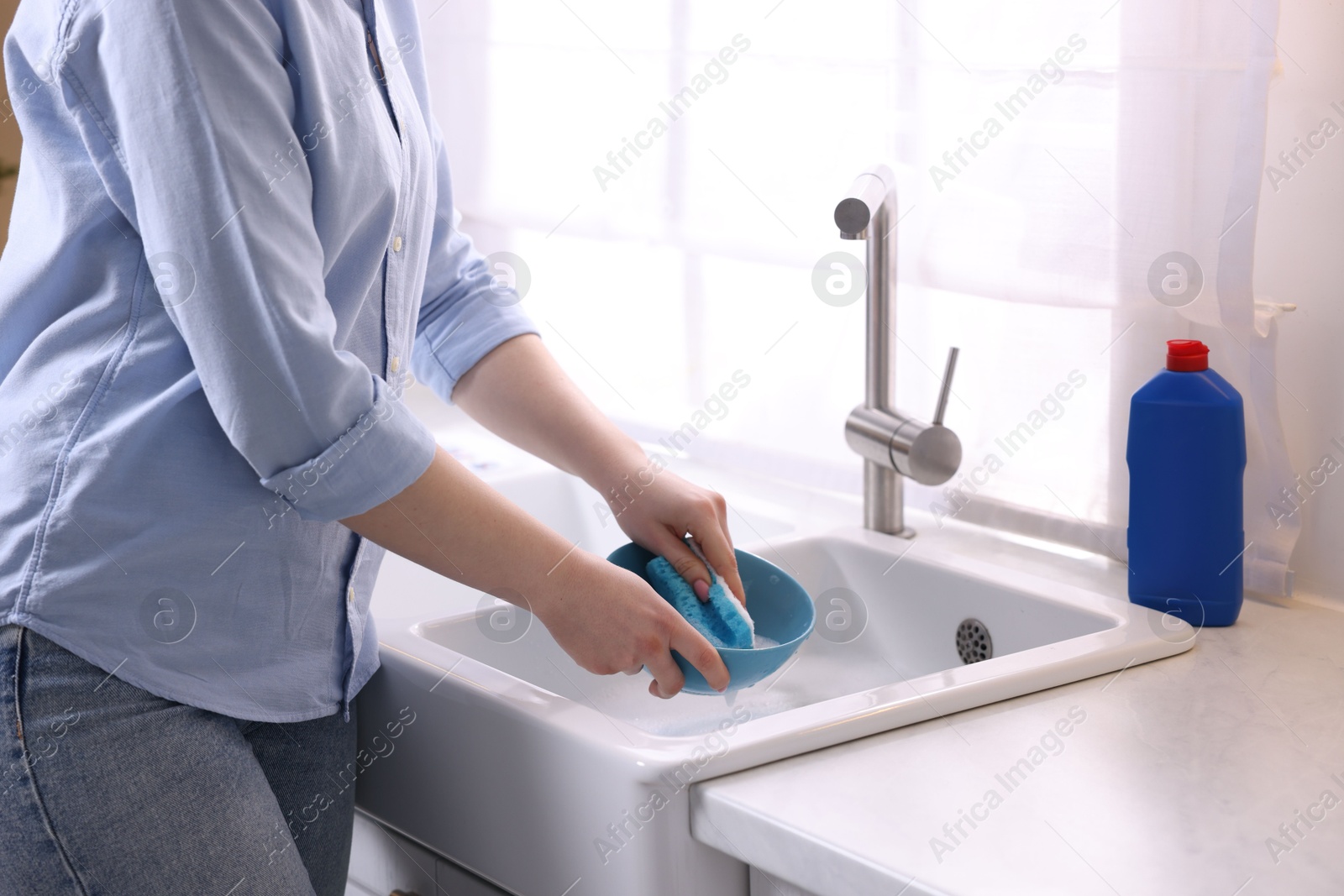 Photo of Woman washing dishes in kitchen sink, closeup