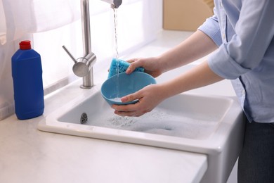 Photo of Woman washing dishes in kitchen sink, closeup