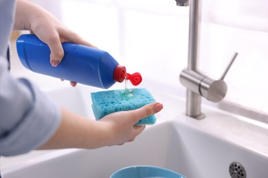 Photo of Woman washing dishes in kitchen sink, closeup