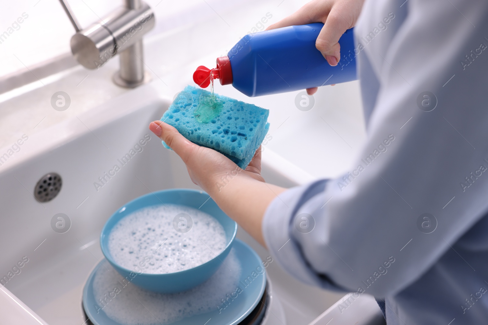 Photo of Woman washing dishes in kitchen sink, closeup