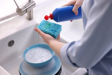 Photo of Woman washing dishes in kitchen sink, closeup