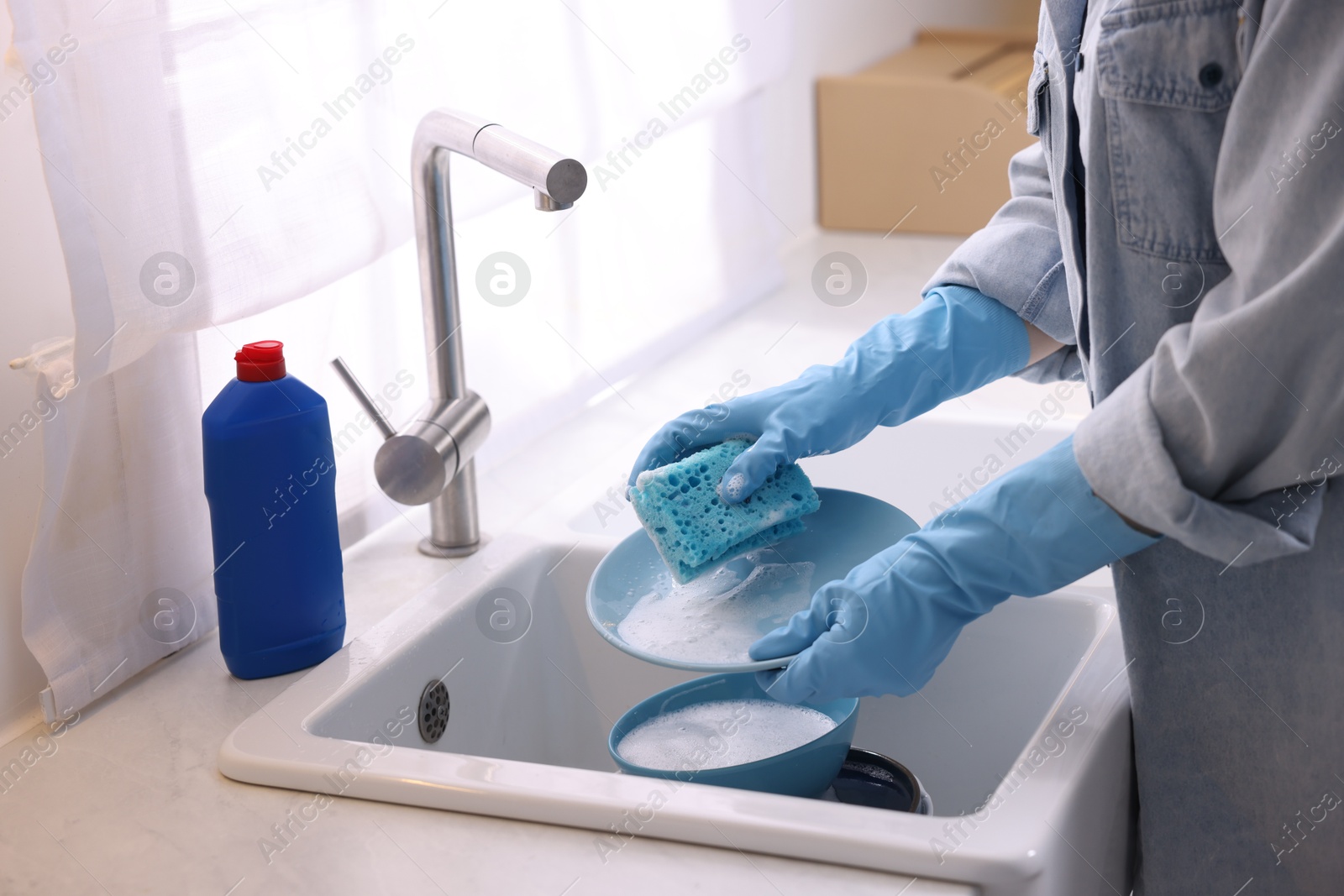 Photo of Woman washing dishes in kitchen sink, closeup