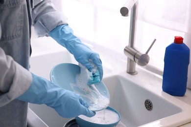 Photo of Woman washing dishes in kitchen sink, closeup