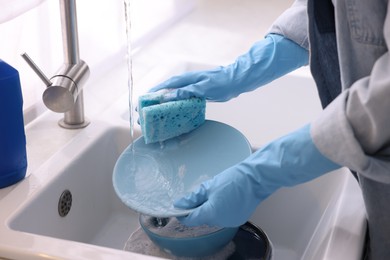 Photo of Woman washing dishes in kitchen sink, closeup