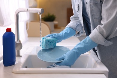 Photo of Woman washing dishes in kitchen sink, closeup