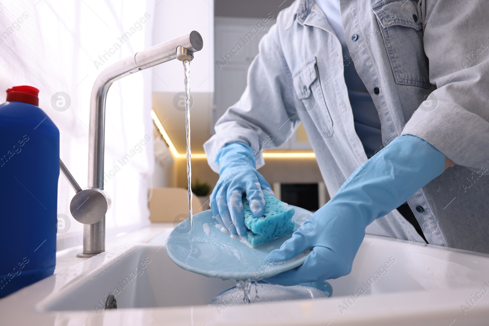 Photo of Woman washing dishes in kitchen sink, closeup