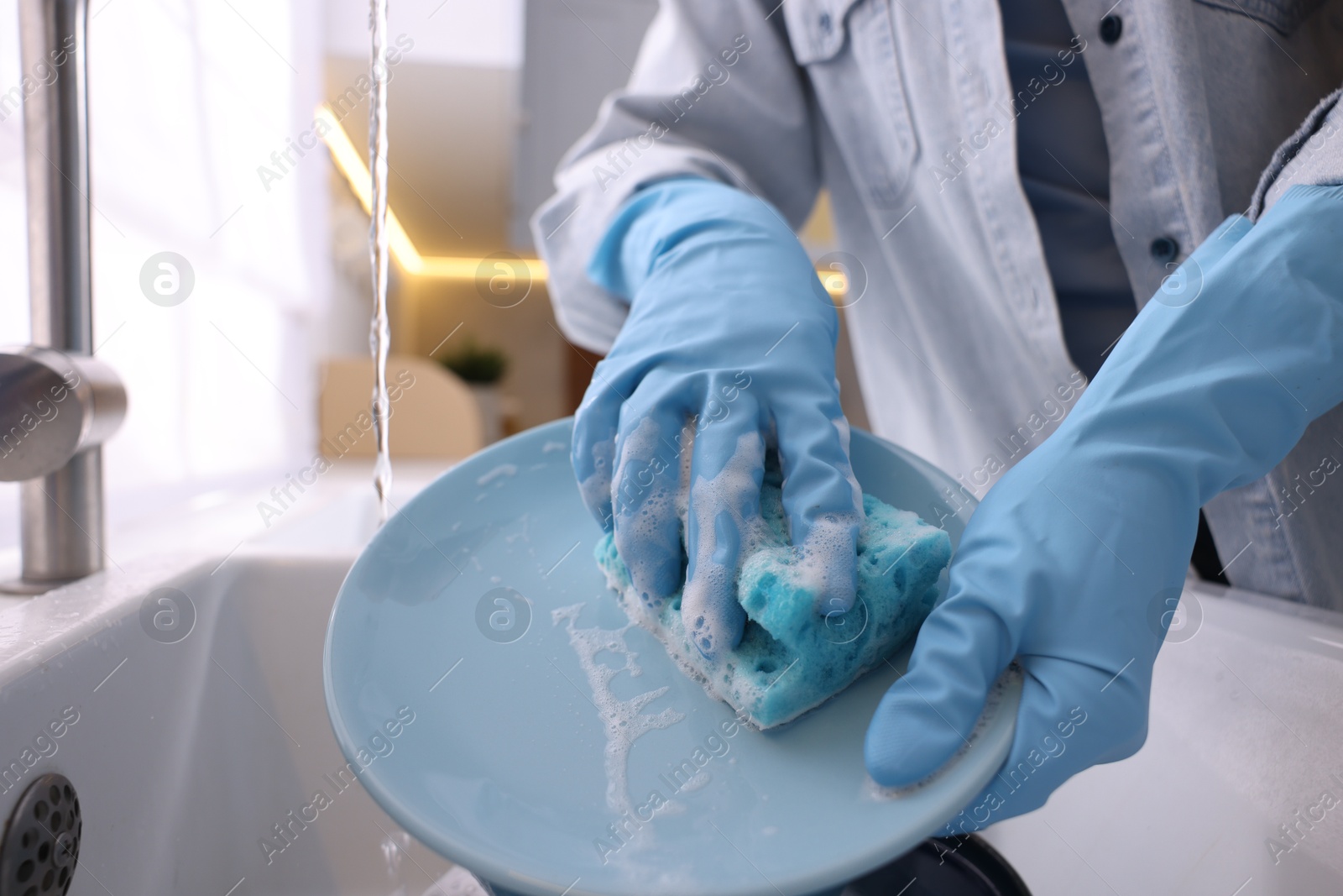 Photo of Woman washing dishes in kitchen sink, closeup