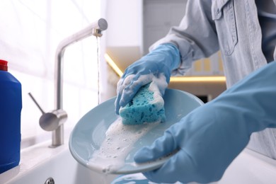 Photo of Woman washing dishes in kitchen sink, closeup