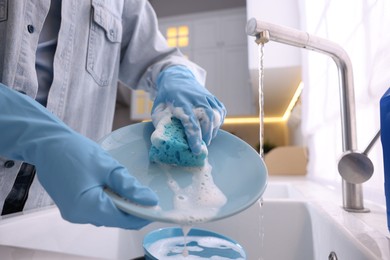 Photo of Woman washing dishes in kitchen sink, closeup