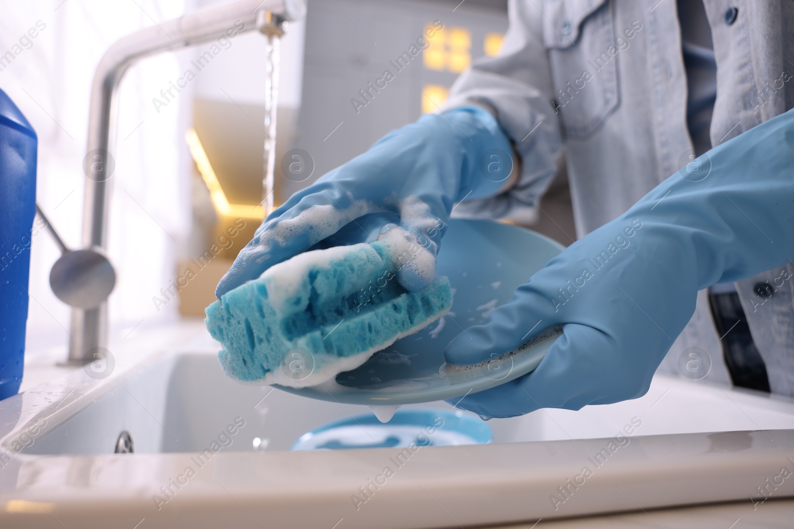 Photo of Woman washing dishes in kitchen sink, closeup