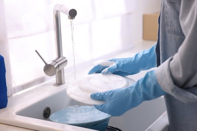 Photo of Woman washing dishes in kitchen sink, closeup