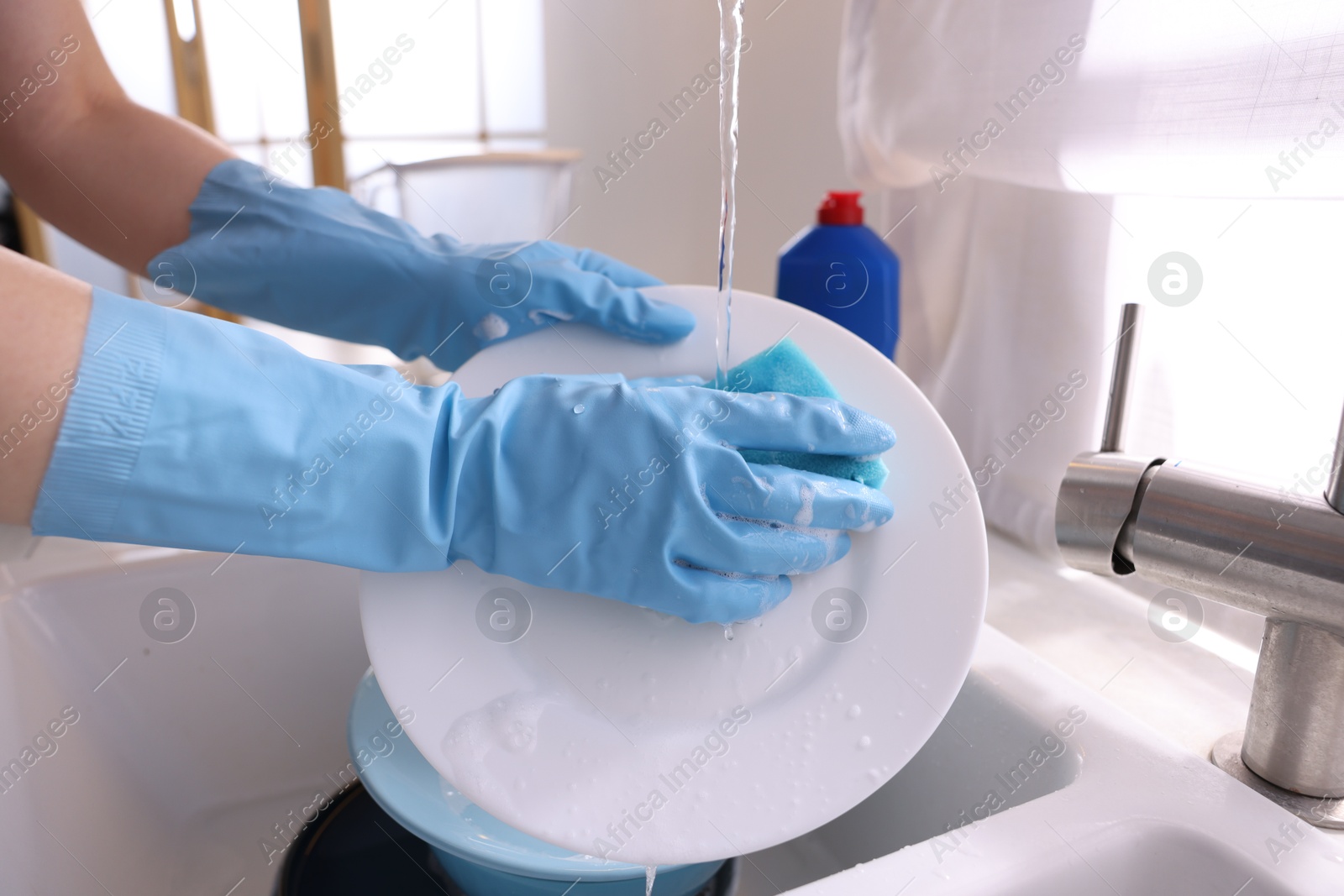 Photo of Woman washing dishes in kitchen sink, closeup