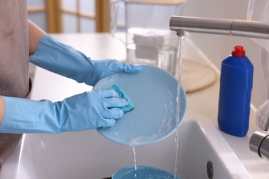 Photo of Woman washing dishes in kitchen sink, closeup