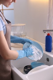 Photo of Woman washing dishes in kitchen sink, closeup