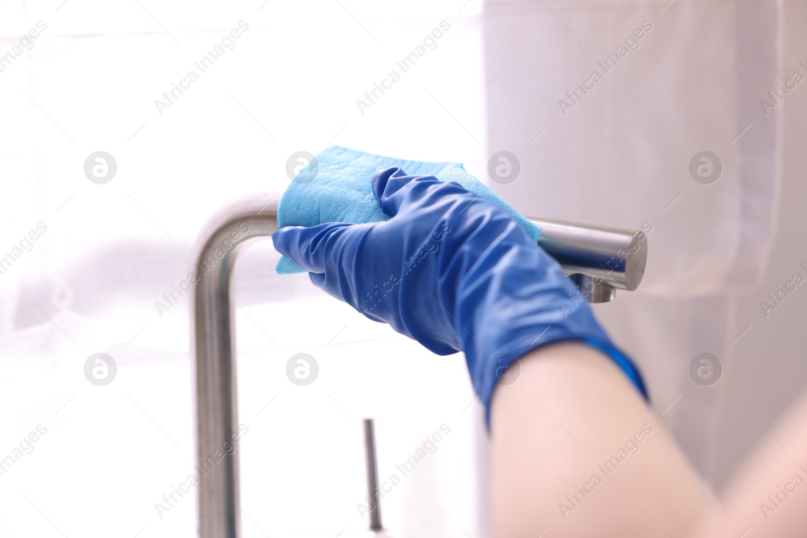 Photo of Woman wiping faucet of kitchen sink with rag indoors, closeup