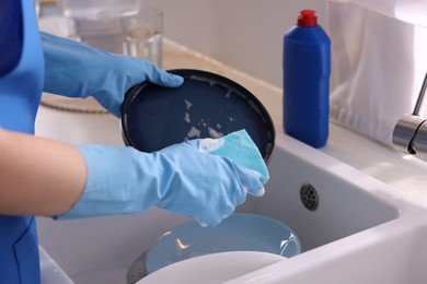 Photo of Woman washing dishes in kitchen sink, closeup