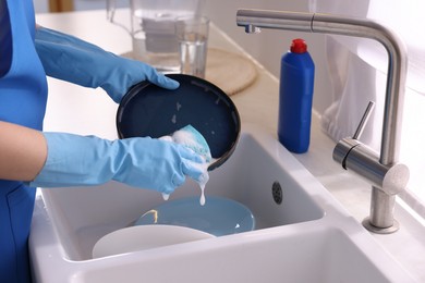 Photo of Woman washing dishes in kitchen sink, closeup