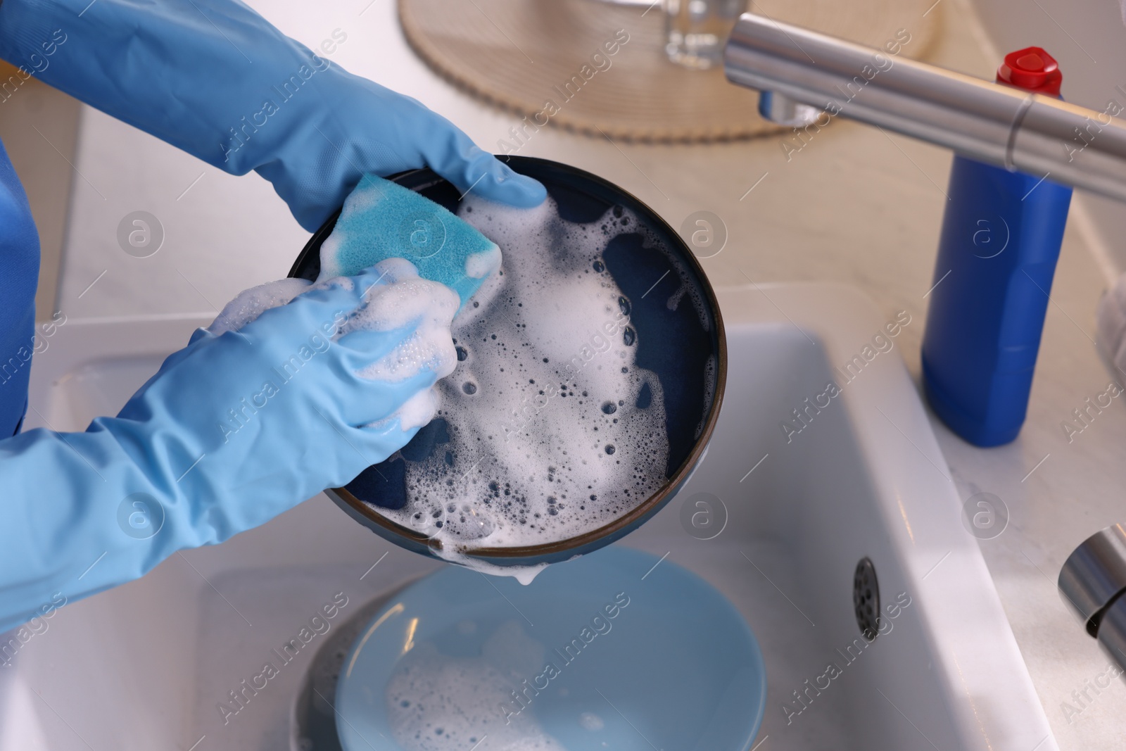 Photo of Woman washing dishes in kitchen sink, closeup