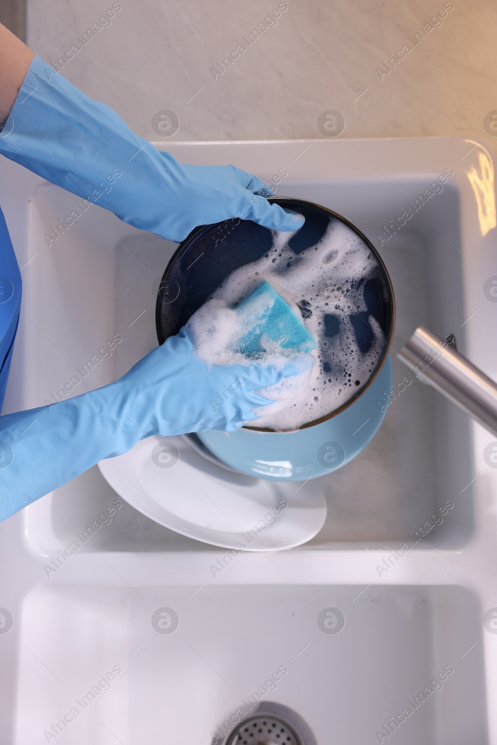 Photo of Woman washing dishes in kitchen sink, top view