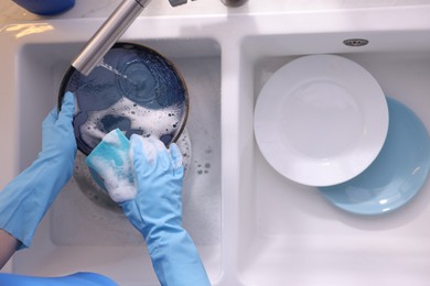 Photo of Woman washing dishes in kitchen sink, top view